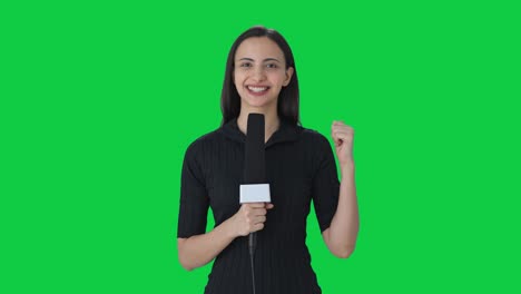 happy indian female news reporter talking to the camera green screen