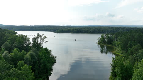 aerial view of arkansas lake with boats on the water, green forest and reflective sky