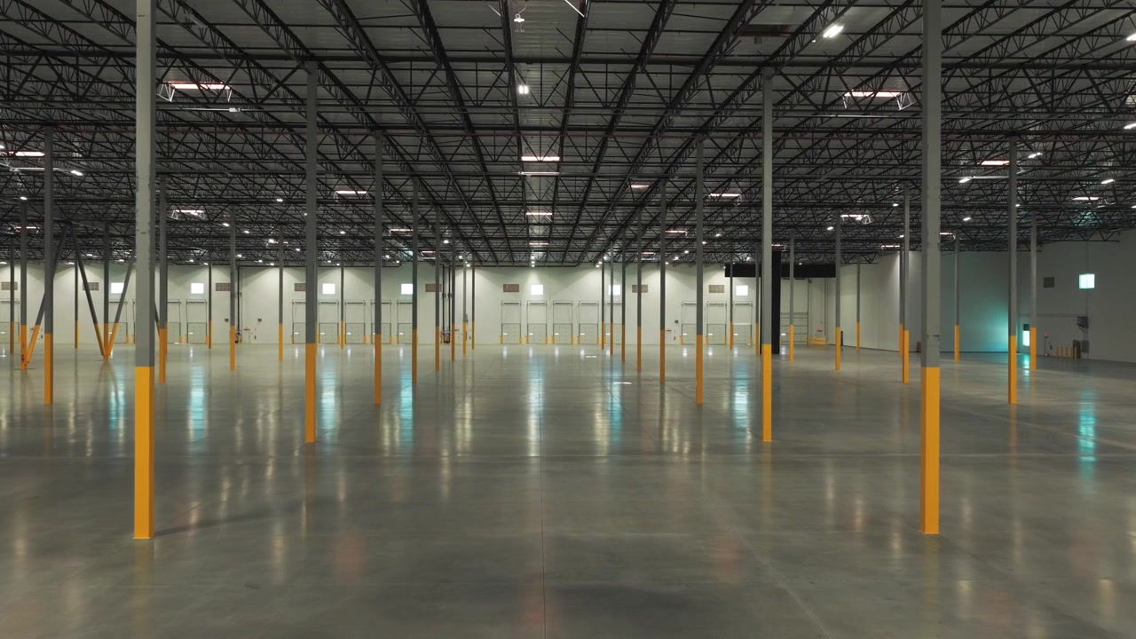 Ripresa aerea ravvicinata delle porte del vano di carico dei camion in un magazzino industriale a Lancaster, California. 4K.