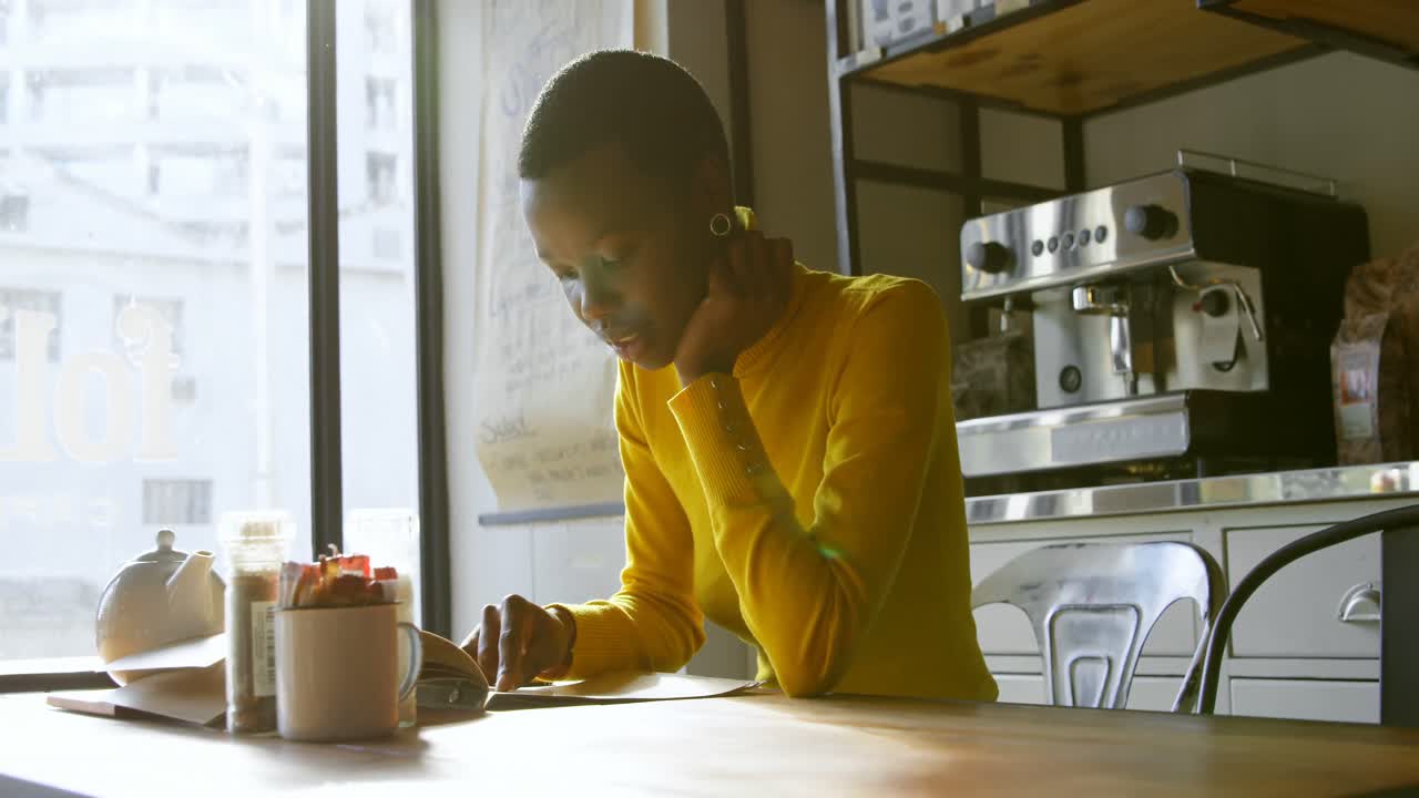 mujer mirando la tarjeta de menú en el café 4k