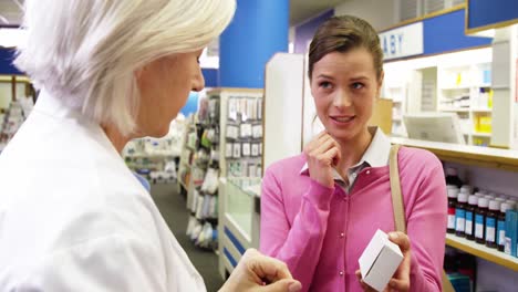 pharmacist assisting the bottle of drug to customer