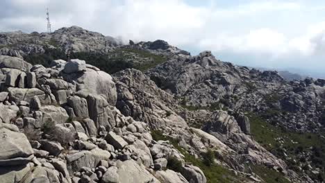 un dron rodea a un tipo parado en la cima del monte limbara en el norte de cerdeña