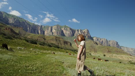 woman walking in a mountain meadow with cows