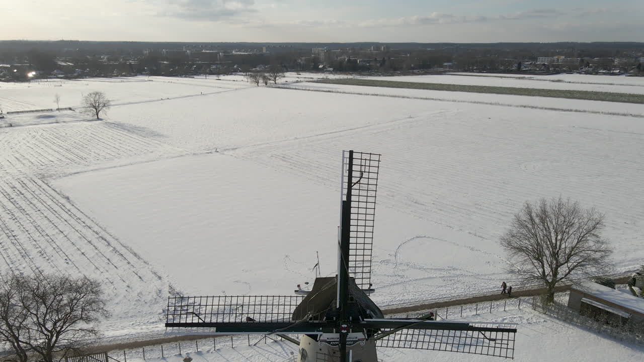 아름다운 눈 덮인 초원에 서 있는 전통적인 네덜란드 풍차의 지브