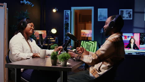 show host adjusting analog mixer settings while talking with guest in studio