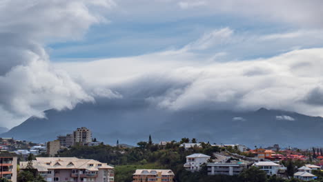 Low-clouds-seem-to-surf-along-mountain-ridge-above-Noumea,-New-Caledonia