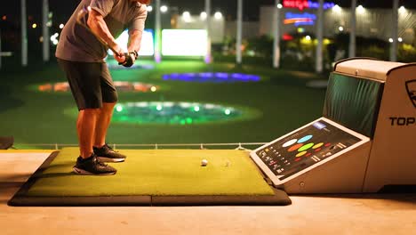 practicing golf swing at a driving range