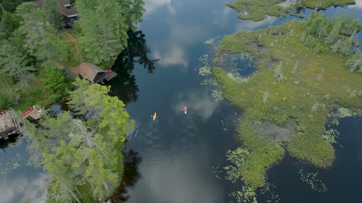 Drone overhead view of 2 kayakers paddling on a summer day on Rainbow Lake in the Adirondack Mountains in New York