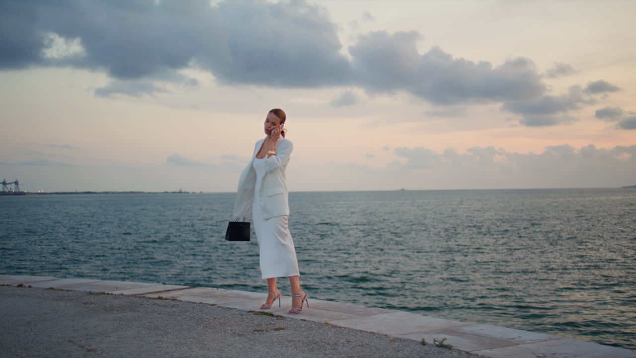 Successful businesswoman calling ocean sunset sky. Lady talking smartphone pier