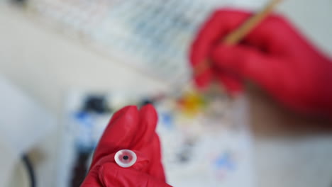 anatomical model of eyeball. close up of hands manufacturing eye prosthesis