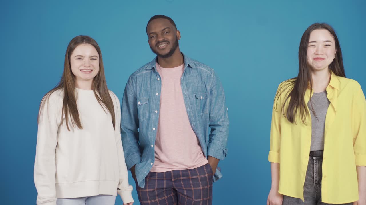Blije en lachende multiculturele vriendengroep danst, heeft plezier en kijkt naar de camera. Mode en kledingstijl.