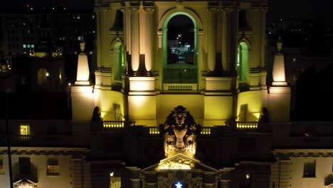 Pasadena-City-Hall-at-night-with-Christmas-tree-and-lights,-rising-drone-view