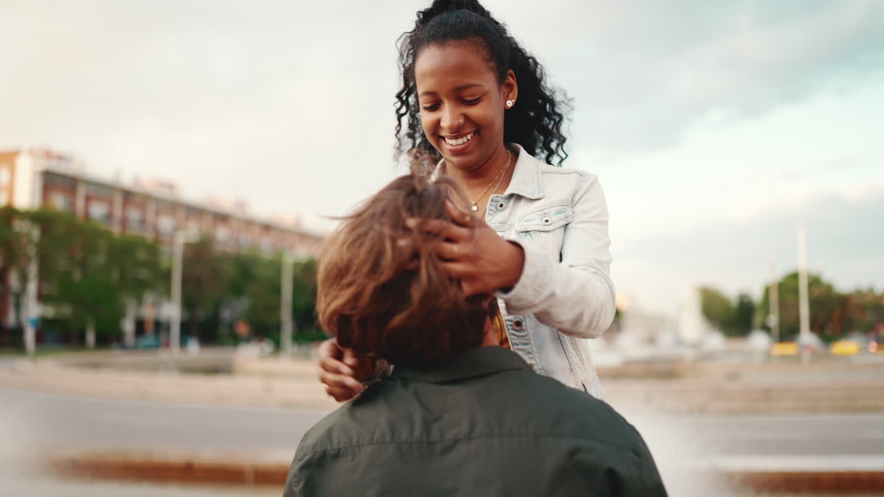 Interracial couple hugging affectionately in an urban setting