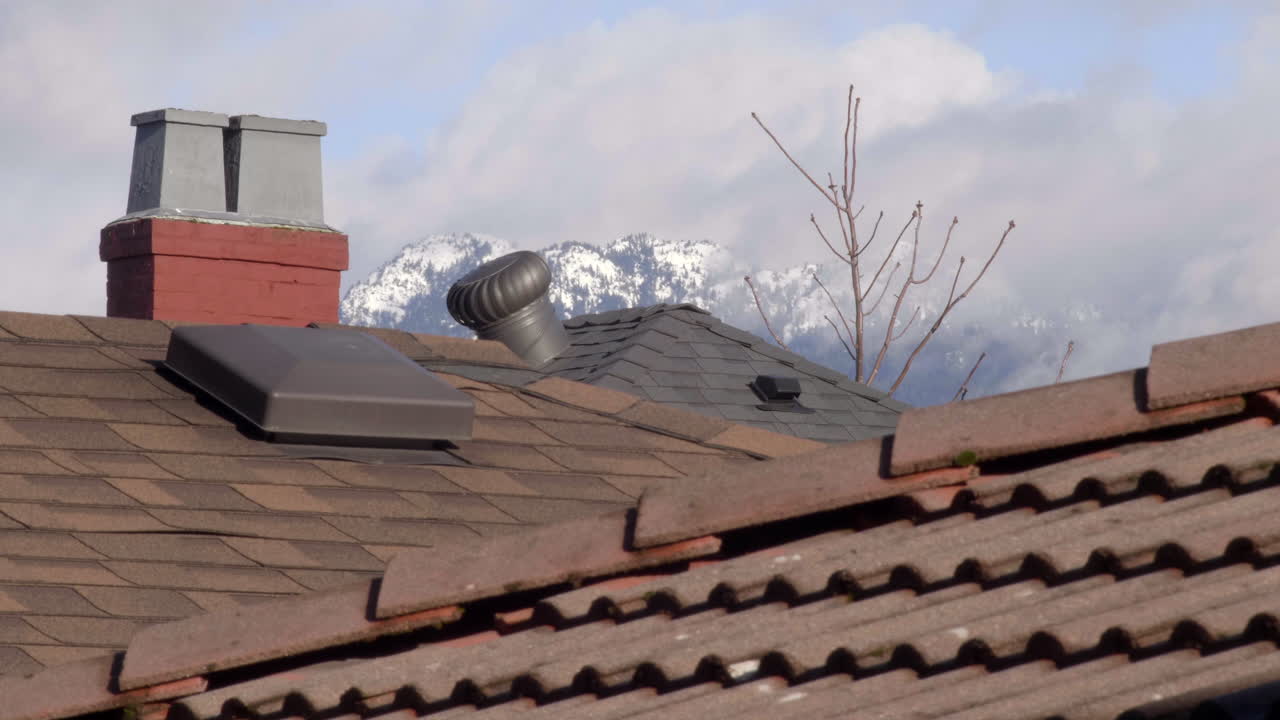 la chimenea de la casa y los respiraderos del techo bajo el cielo nublado durante el invierno - primer plano
