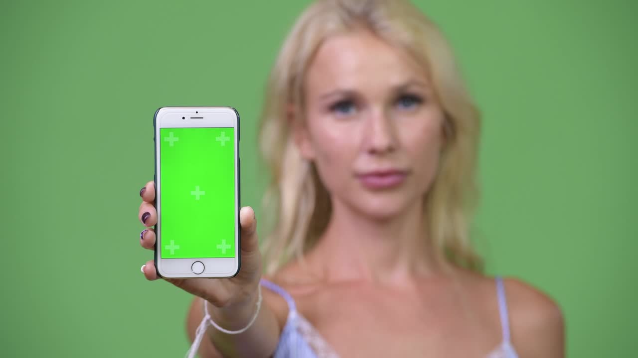 Young happy beautiful businesswoman showing phone