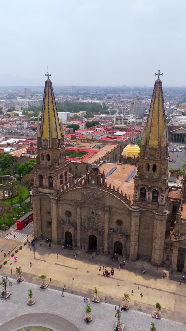Vista frontal elevada da Catedral de Guadalajara com torres de telhas amarelas, Fuente de Guadalajara e Praça no centro histórico da cidade
