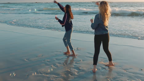 best friends blowing bubbles on beach at sunset teenage girls having fun summer playing by the sea enjoying friendship