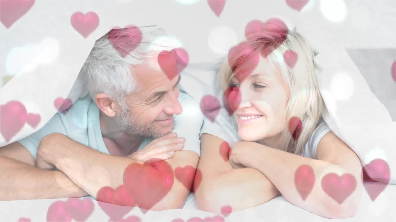 una pareja feliz y madura acostada en la cama.