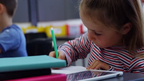 una colegiala linda dibujando cuadros en el aula