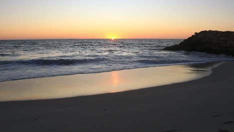 sun rising in the distance over a peaceful and calm australian coastline