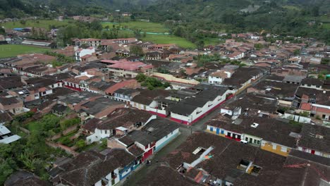 aerial above historic countryside town of salento, colombia, with view on pedestrian houses and mountain landscape.