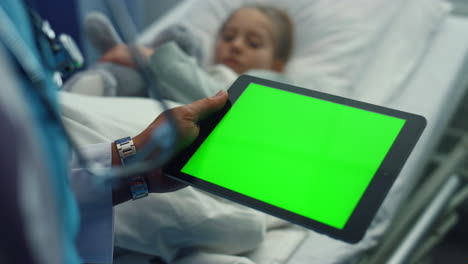 doctor hand holding chroma key tablet computer device in hospital ward closeup.