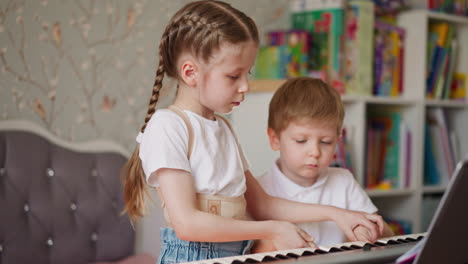 Mädchen-Nimmt-Die-Finger-Des-Kleinen-Bruders-Und-Spielt-Zu-Hause-Klavier