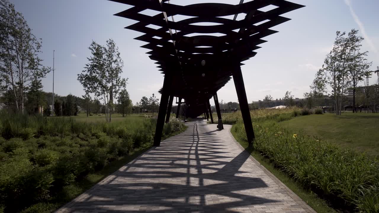 camino de parque moderno bajo pérgola metálica