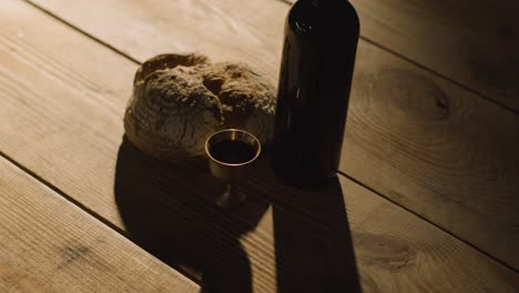 tiro de concepto religioso con pan de cáliz y vino en mesa de madera con piscina de luz 1