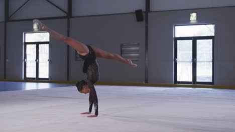 teenage female gymnast performing at sports hall