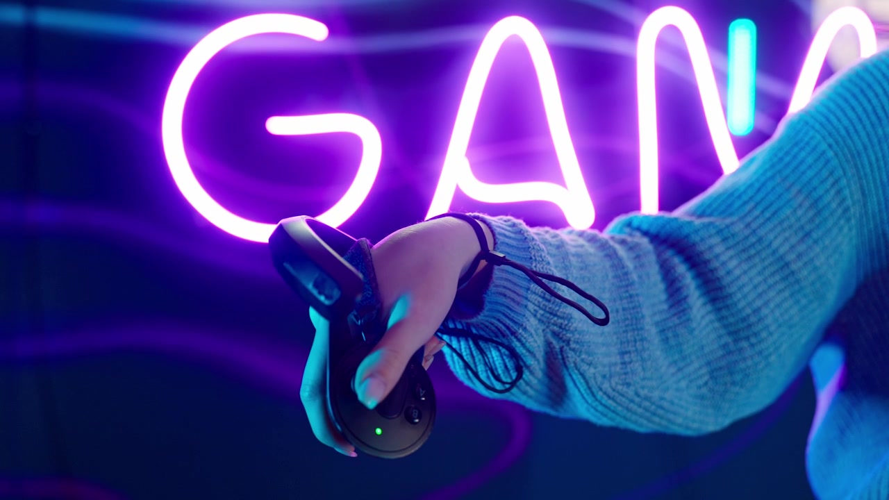 Close-up of Hand Holding VR Controller in Neon Lit Gaming Environment