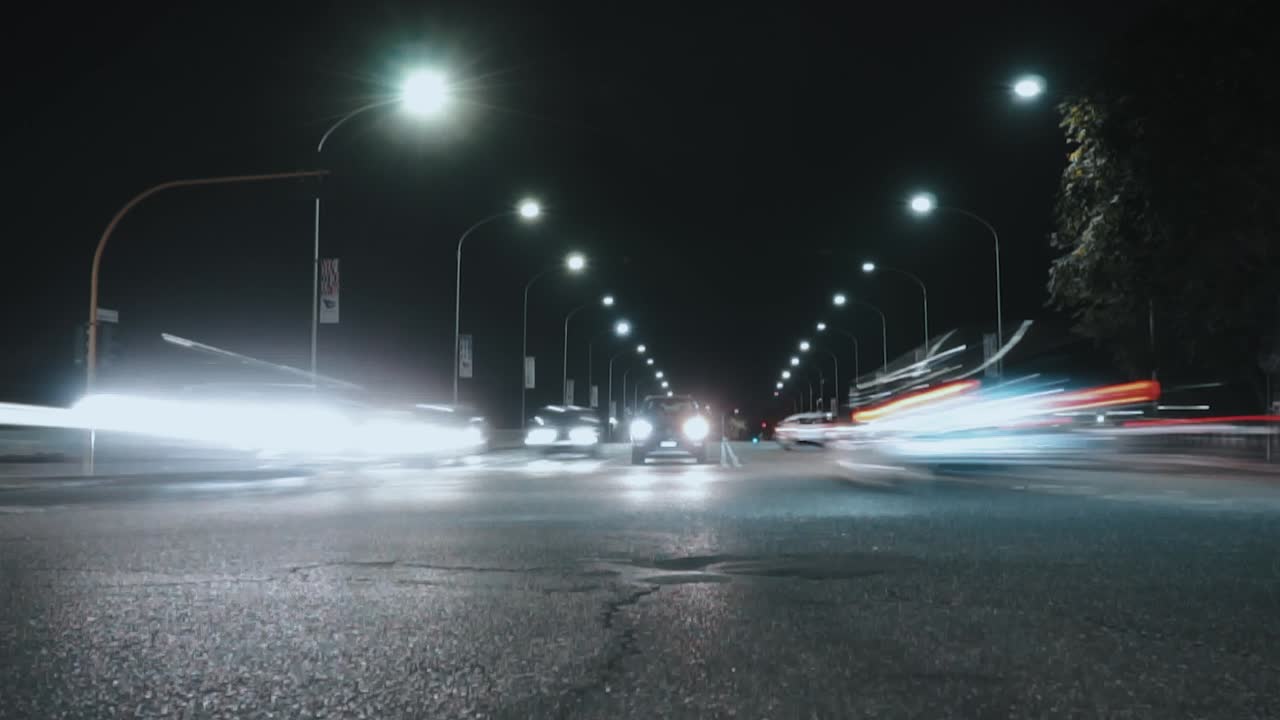 Auto che guidano in direzioni diverse di notte nel traffico. ZOOM OUT TIMELAPSE.