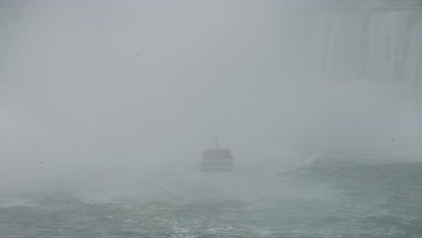 boat in storm in the mist in falls can hardly be seen niagara falls