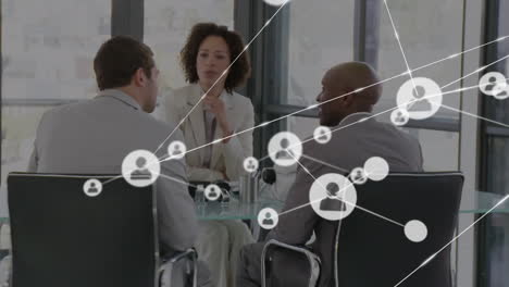 animation of network of profile icons against diverse businesspeople discussing at office