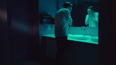 man in a restroom, reflecting on his anxiety