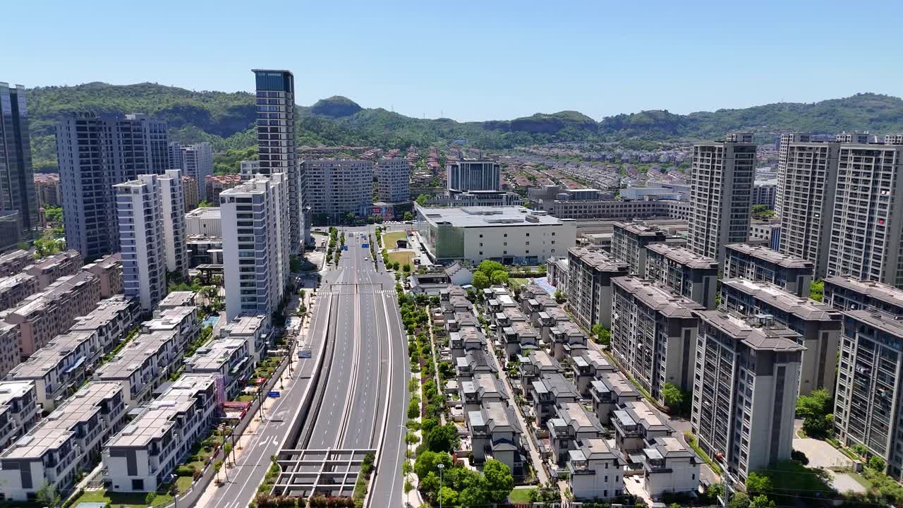 Aerial: Shaoxing cityscape during the day with high-rise buildings and roads in northeastern Zhejiang province, China, pan drone shot