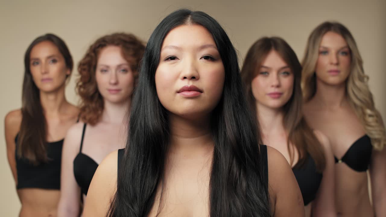 속옷 을 입은 자신감 있는 여자 들 의 그룹 이 카메라 를 바라보고 한 줄 에 서 있다