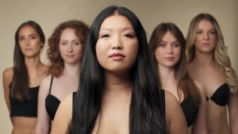 속옷 을 입은 자신감 있는 여자 들 의 그룹 이 카메라 를 바라보고 한 줄 에 서 있다