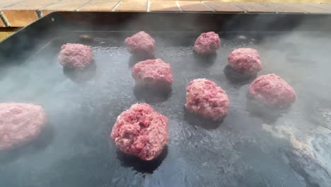 burger patties smoking on hot grill