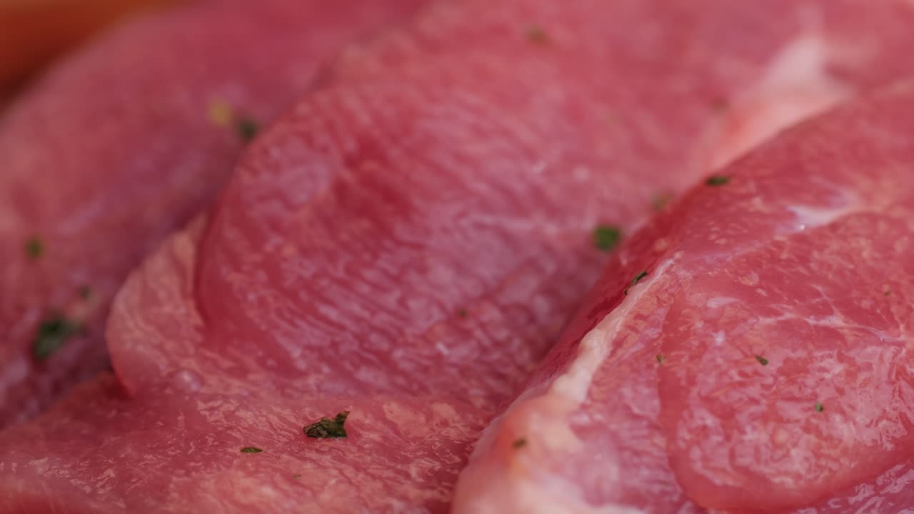 Raw slice beef meat in spices: paprika, salt, pepper, turmeric on plate close-up. Preparing raw food for cooking. Grill and Fry beef, pork, chicken, duck, turkey kebab with vegetables.