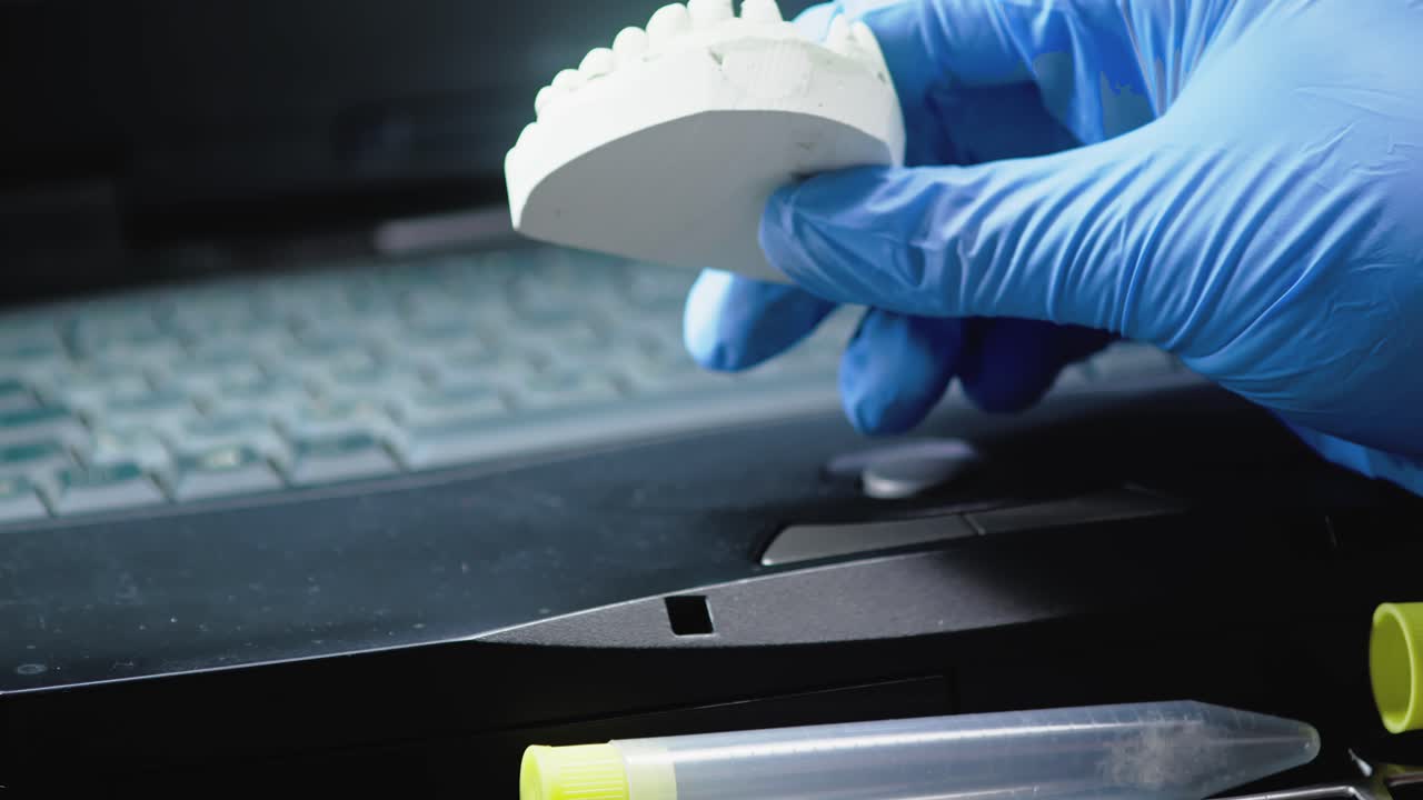 Dental Technician Examines and documents Denture Casting in Lab
