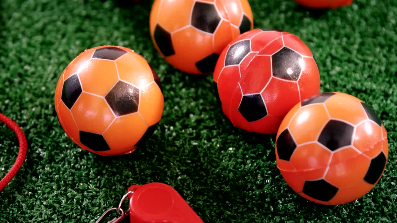 Palloni da calcio e fischietto dell'arbitro su erba sintetica 4k