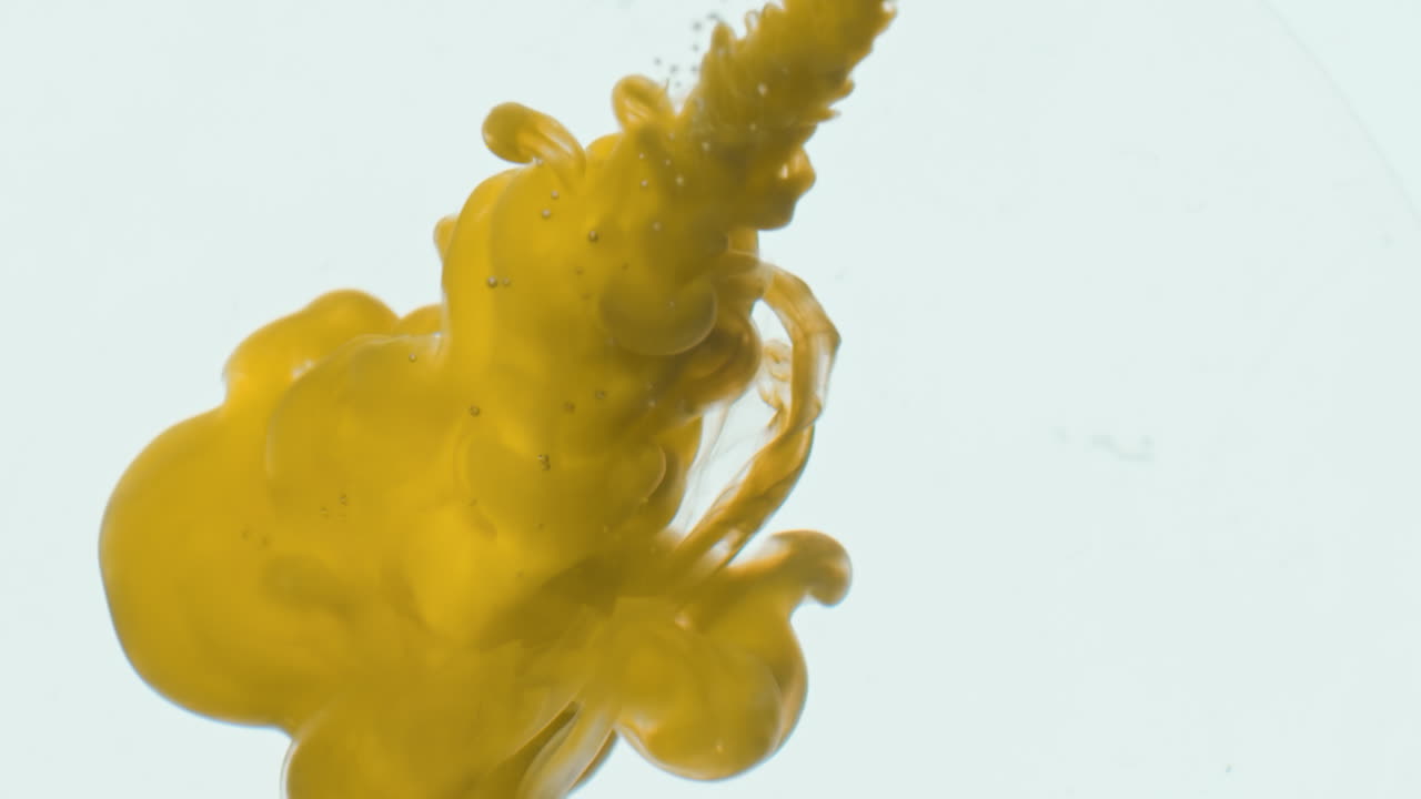 Nube de tinta amarilla en agua