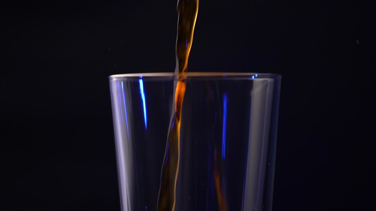 Iced coffee being poured into a pint glass