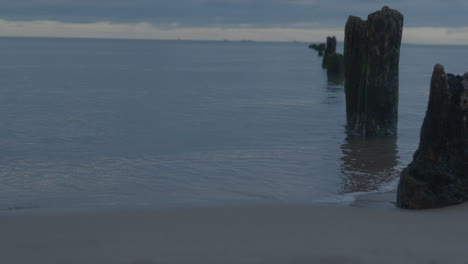 Calm-Sea-With-Old-Wooden-Pole-Heads-At-Dawn-In-Górki-Zachodnie,-Gdańsk-Poland