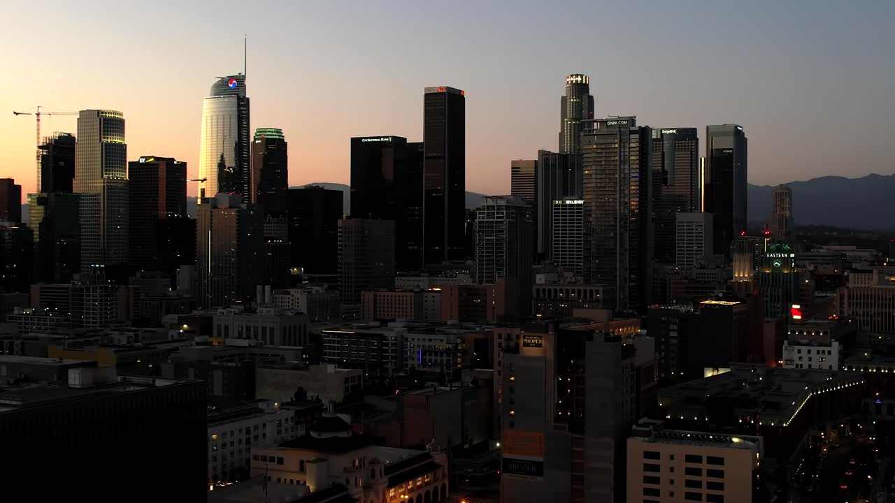 Vista aerea del centro di Los Angeles al tramonto, grattacieli stagliati contro un cielo colorato durante l'ora d'oro, un iconico paesaggio urbano in California