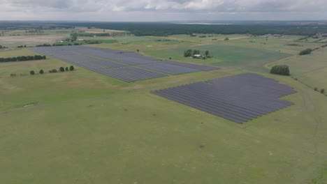 Gran-Parque-De-Células-Solares-En-La-Suecia-Rural-En-Un-Campo-Agrícola-Verde-Durante-El-Mal-Tiempo