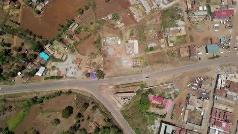 Aerial-view-of-a-town-sunlit-field,-golden-hour-in-rural-Africa---tracking,-drone-shot