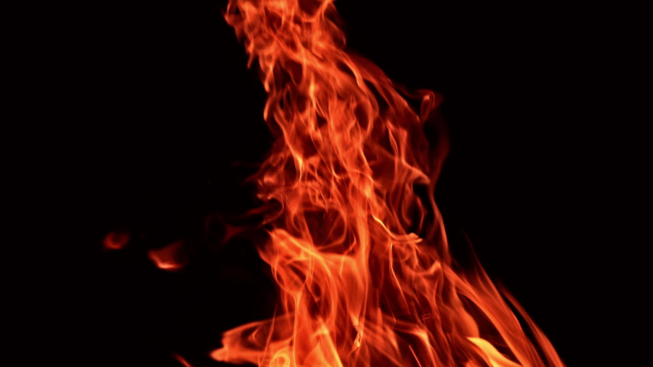 Beautiful flame of burning campfire rising up. Fire isolated on black backdrop. Close up.