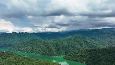 Cinematic-drone-flight-over-scenic-mountain-landscape-with-green-plants-and-green-river-during-cloudy-day---Taiwan,-Asia---Aerial-forward-movement